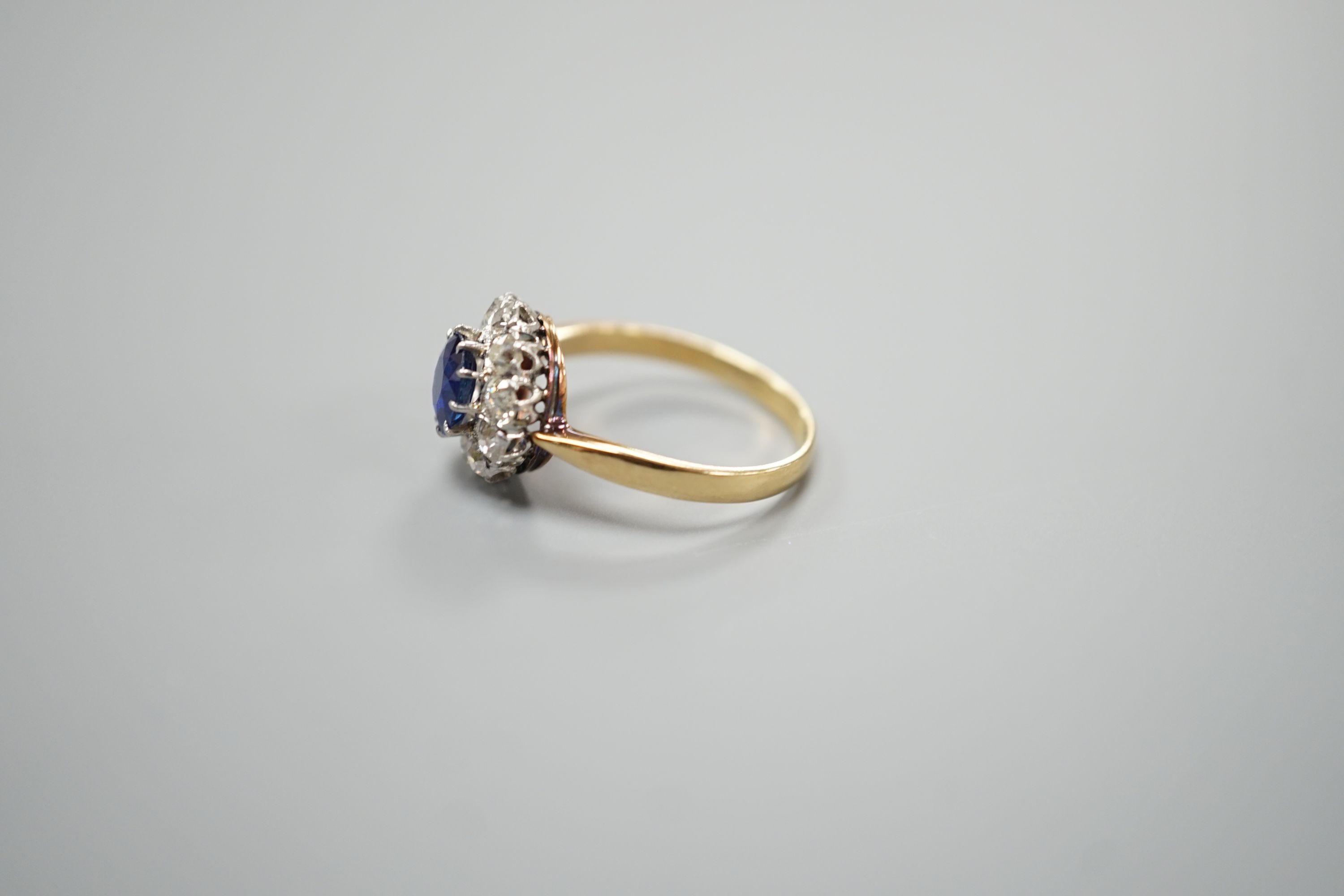 A yellow metal, sapphire and diamond set circular cluster ring, size N/O, gross weight 3.1 grams.